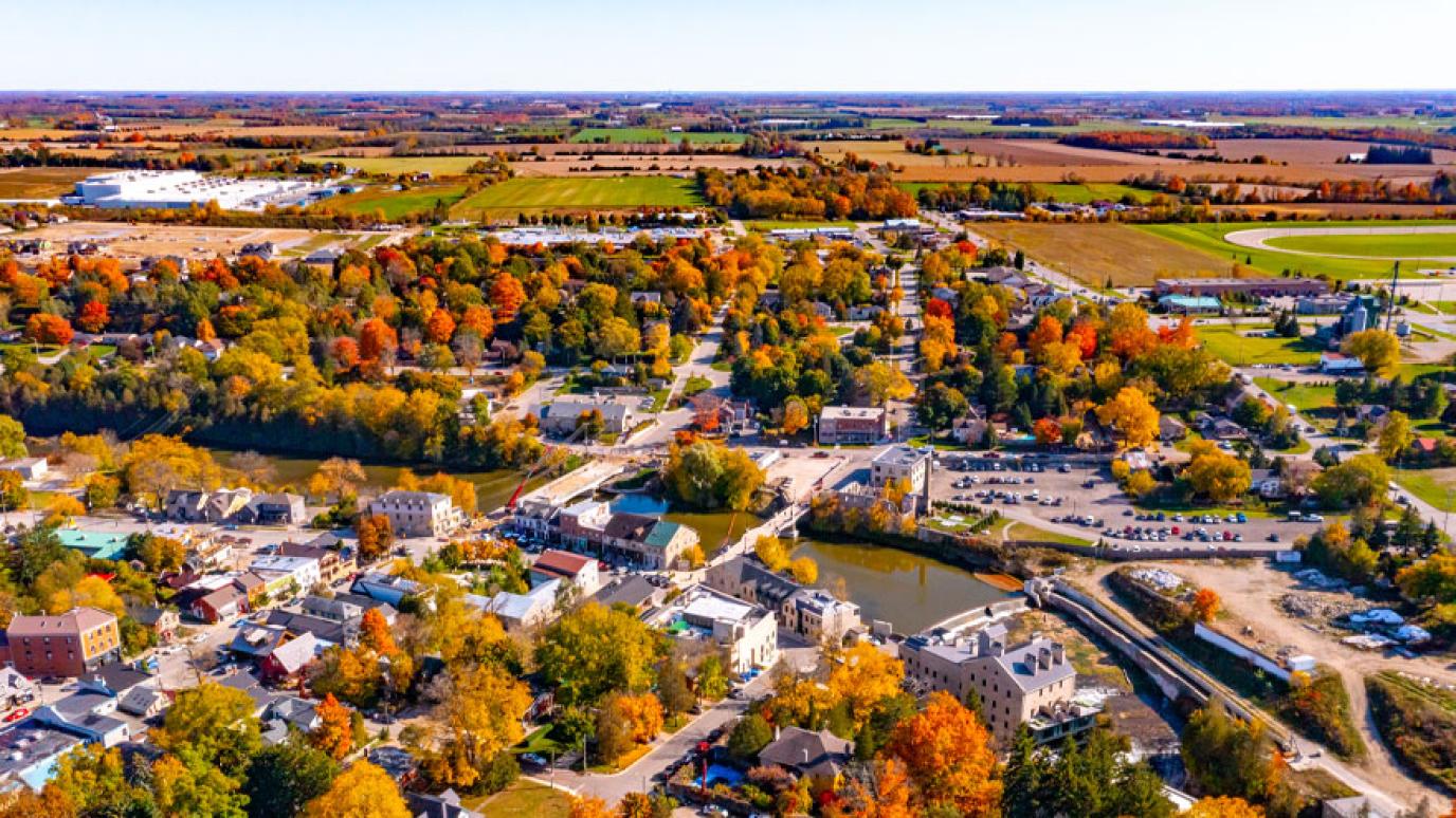 Birds eye view of Elora looking South to neighboring fields into horizon on bright autumn day