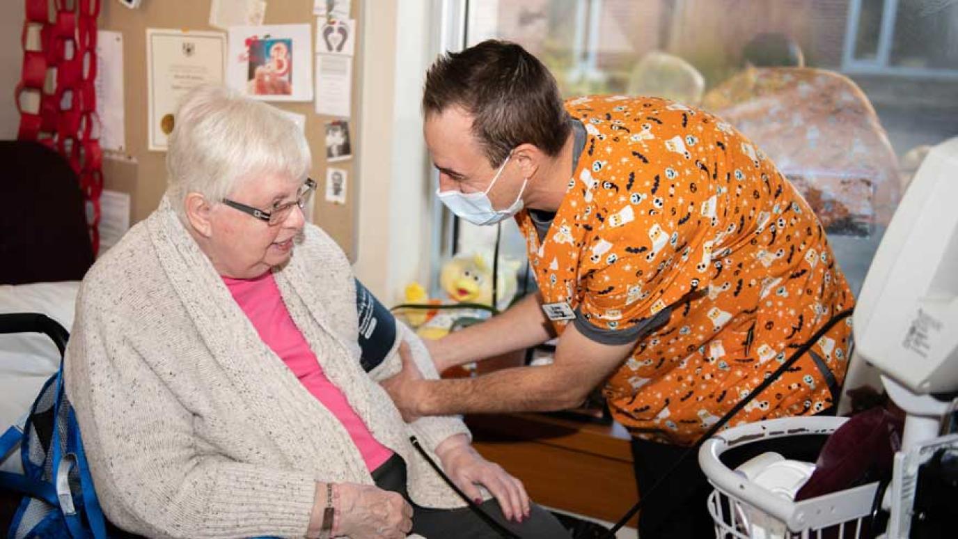 A smiling aide takes a residents blood pressure at the Wellington Terrace