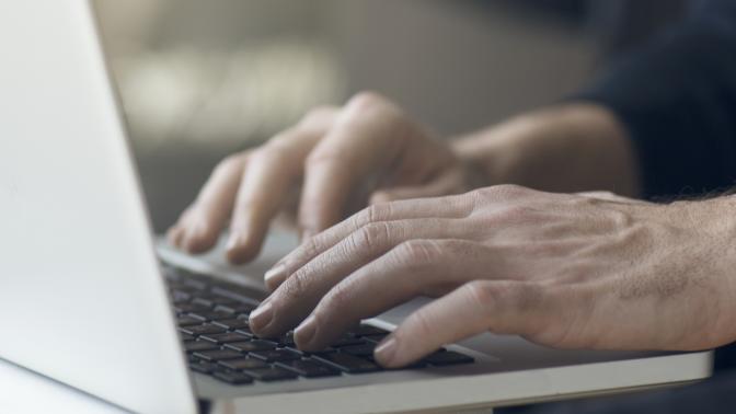 Close up of hands typing on laptop computer