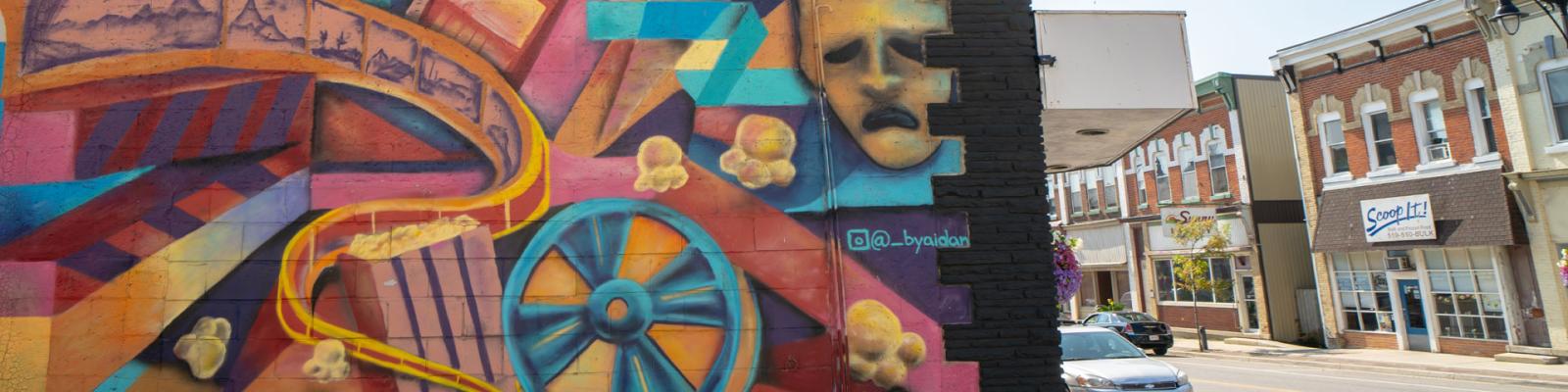 Colourful theatrical mural on the side of a building downtown Minto