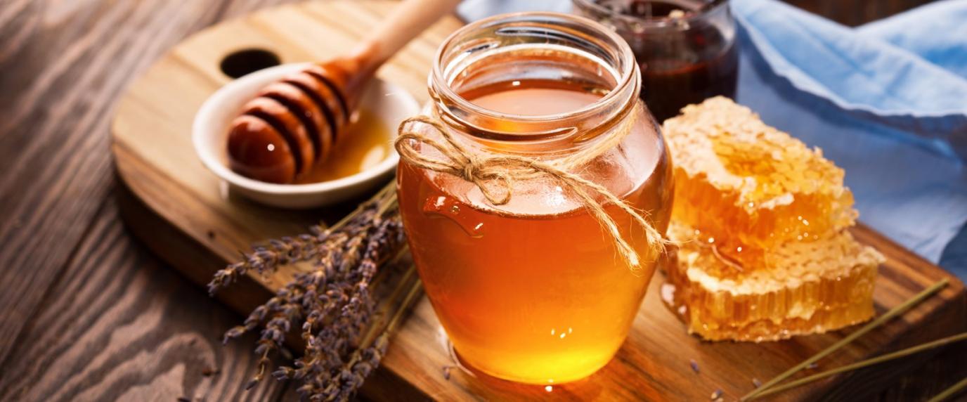 jar of honey and honeycomb on a table