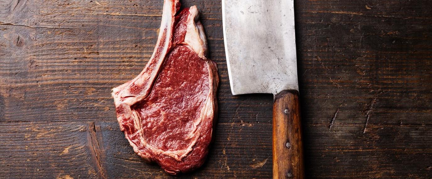 steak and butcher knife on a cutting board